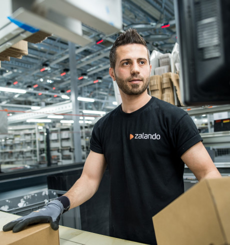 Logistics employee in black Zalando shirt handling boxes