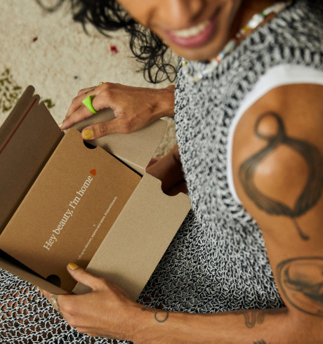 Kundin packt einen kleinen Karton aus, darauf steht: Hey beauty, I'm home