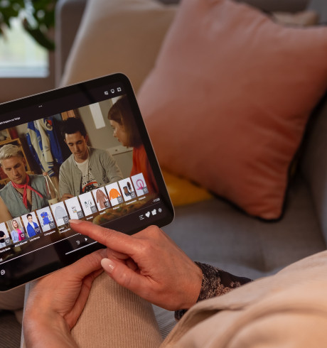 Customer with tablet: on screen GZSZ ist playing, underneath fashion items to chose from