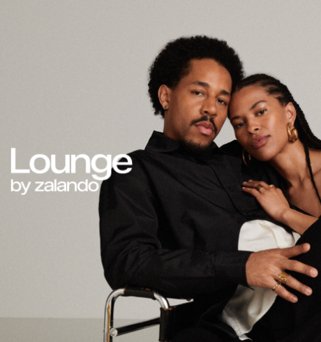 Lounge by zalando - A Black couple sitting comfortably on a chair; his arm around her, her head on his shoulder