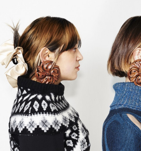 Headshot of two fashion models, both wearing warm jumpers and the same large distinctive earrings