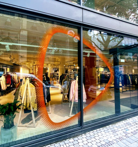 Storefront, Zalando brand beacon on a glass front, clothes can be seen inside