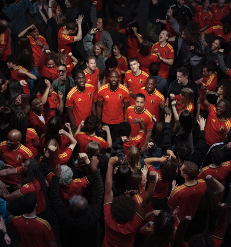 Five RBFA players standing in a celebrating crowd; only these five are looking up into the camera