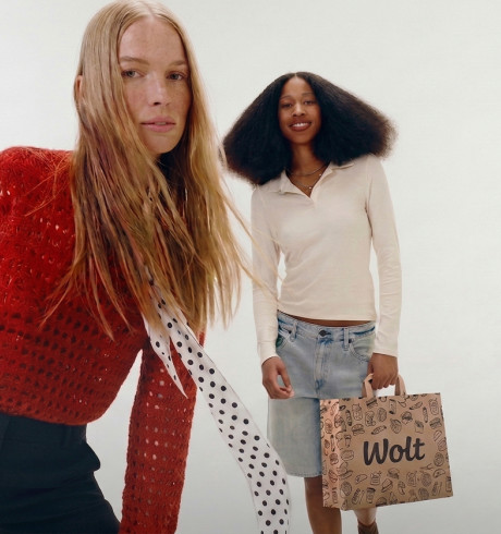 Two models, one of them carrying a Wolt bag
