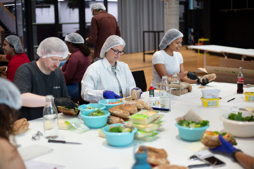 Volunteers at a table preparing sandwiches