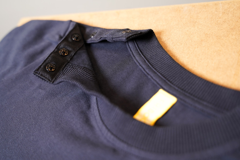zoom image on the buttoned collar of a dark blue t-shirt