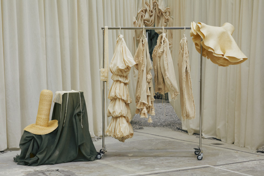 Clothes rack at fashion show displaying different garments in natural tones
