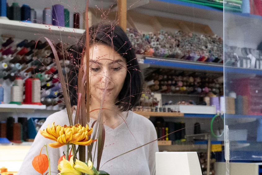 A woman behind a cash register of a tailor's shop