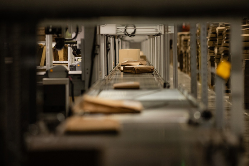 low level view along a dark conveyor belt carrying bags and parcels