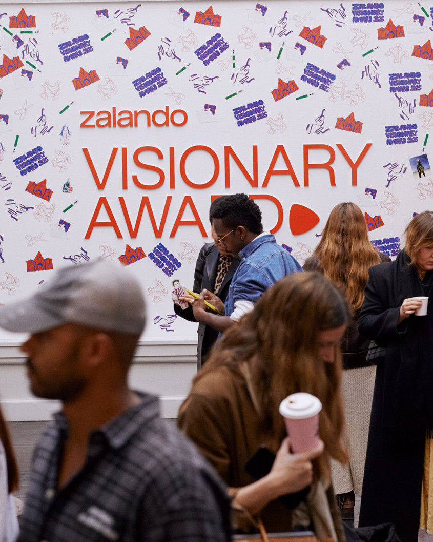 Audience in front of a colourful Zalando Visionary Award backdrop