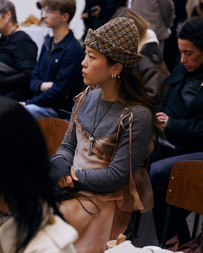 A woman sitting in the audience, listening