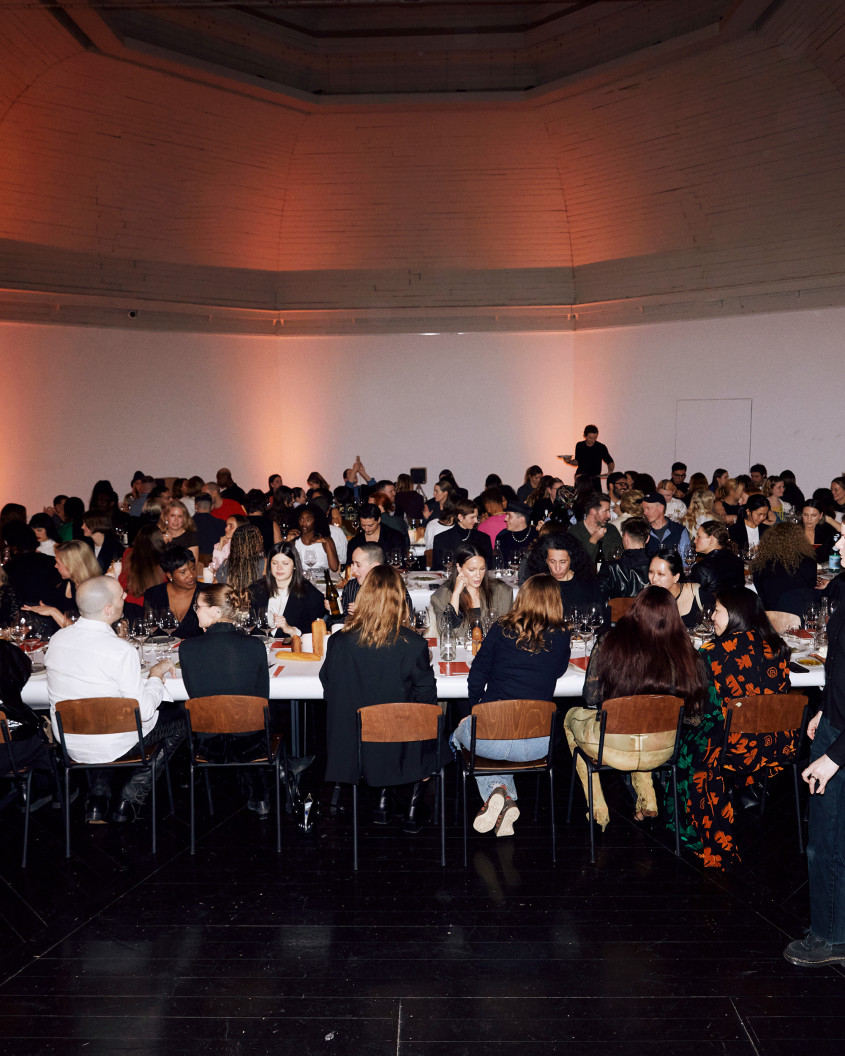 The guests sitting at long tables during dinner