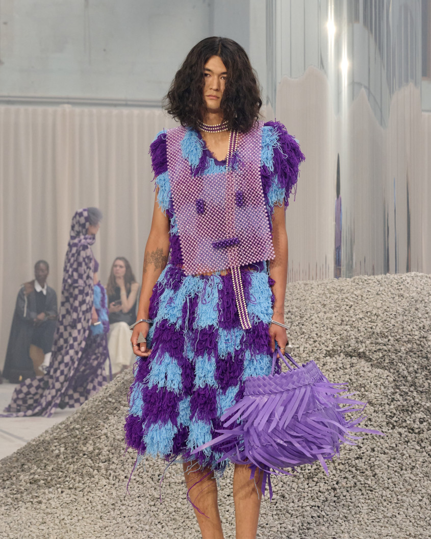 Fashion model wearing a blue and purple chequered dress and big purple bag