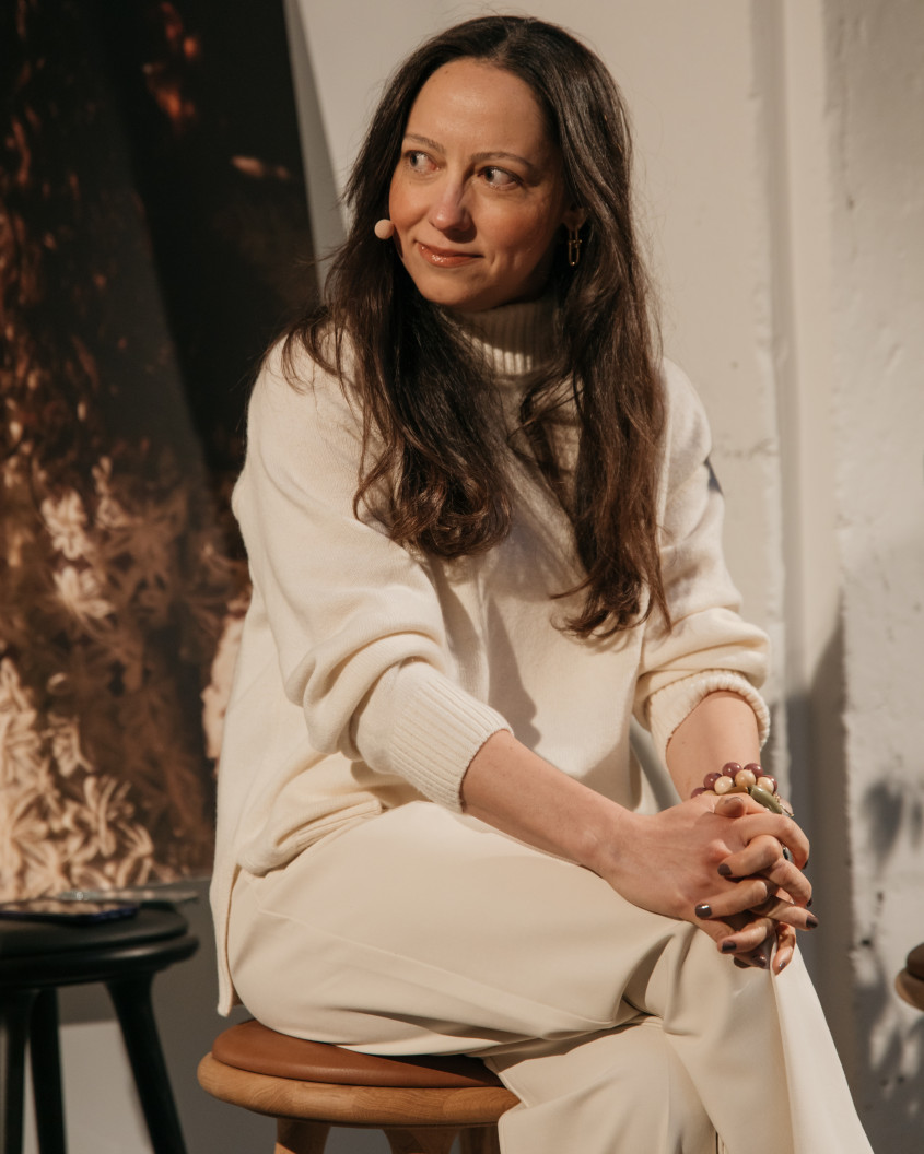 Pelin Anli Bedirhanoglu sitting on a chair, listening to the discussion