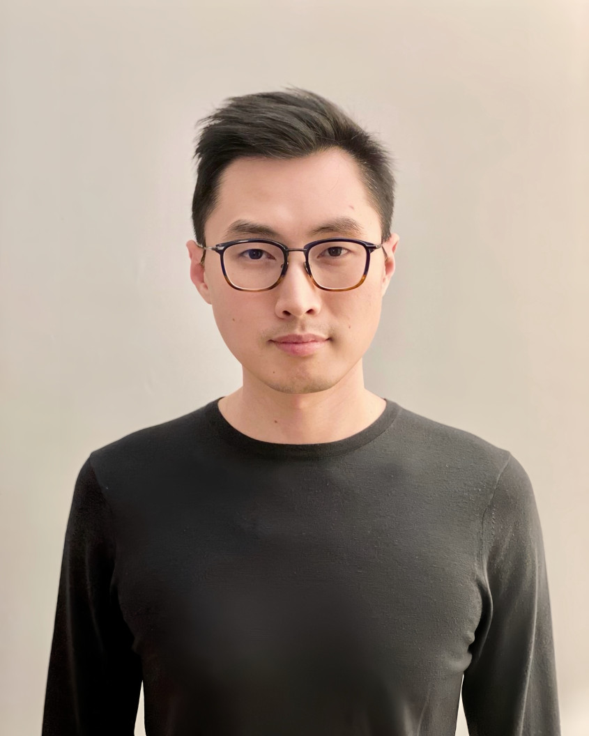 Portrait of Ray Cao in a black long sleeve and dark-rimmed glasses