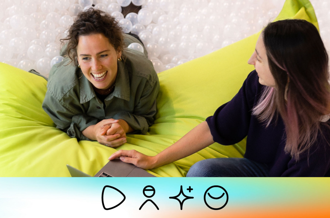 Zwei Zalando Mitarbeiterinnen arbeiten zusammen, und sitzen auf einem großen Kissen in einem Bällebad