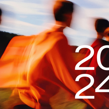 2024 - blurry background image showing a group of people walking in the golden light of low sun