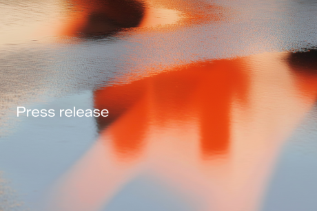 Press release - abstract image of what looks like red-golden reflections in a puddle