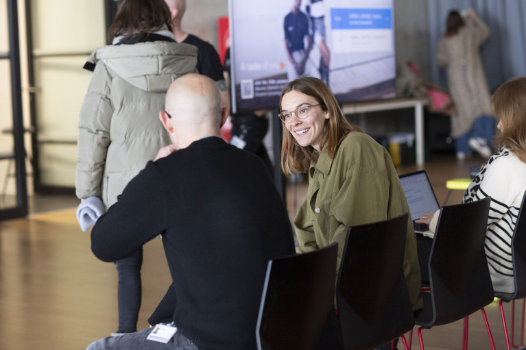 Two people, a man and a woman, are chatting in an auditorium