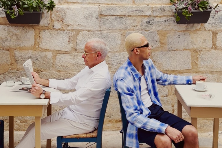 Two men sitting back to back