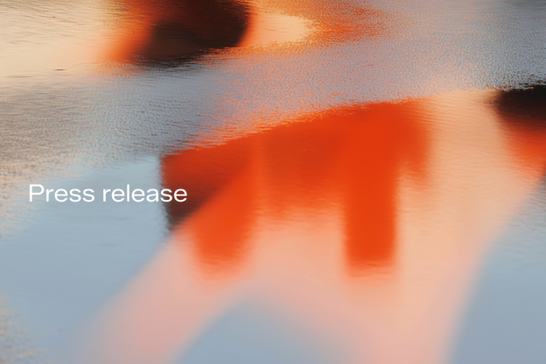 Press release - abstract image of what looks like red-golden reflections in a puddle