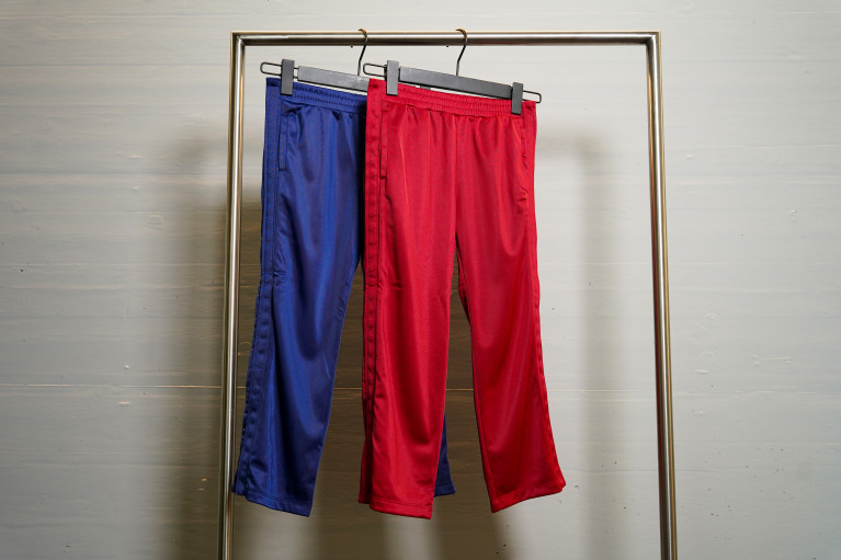 blue and red trainer pants with buttons at the sides