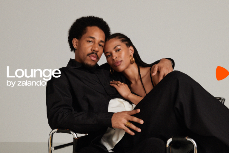 Lounge by zalando - A Black couple sitting comfortably on a chair; his arm around her, her head on his shoulder