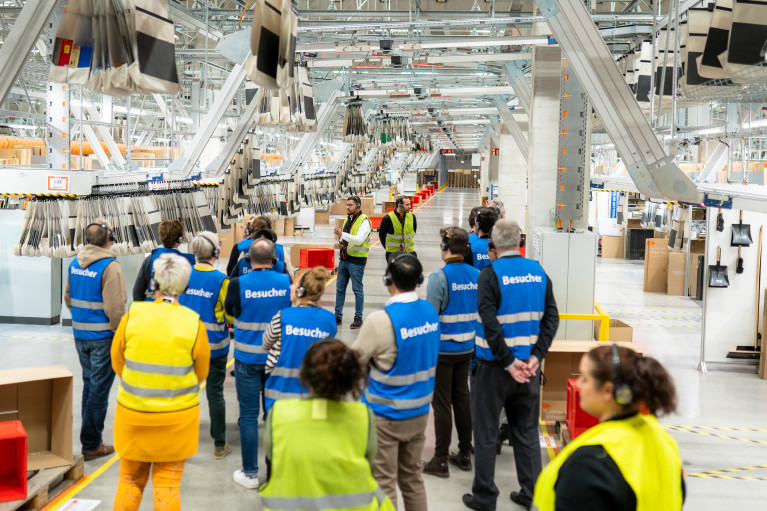 Logistics workers gathered in a fulfilment center hall