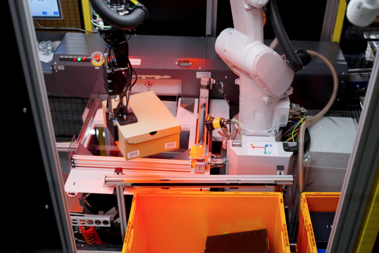 AI-driven Nomagic robot picking up a shoebox