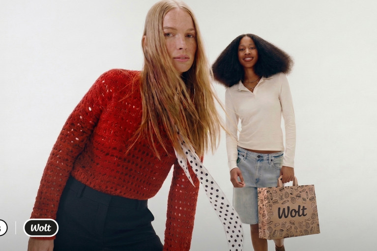 Two models, one of them carrying a Wolt bag